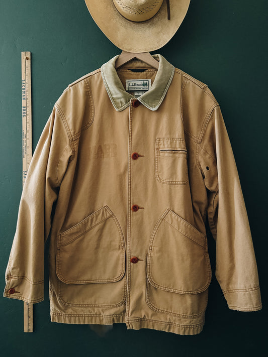 Beige jacket with a hat on a dark green background